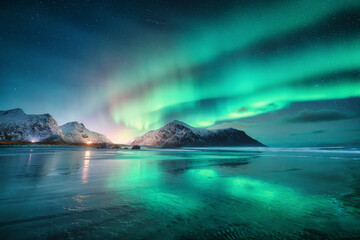 Northern Lights and sandy beach at starry winter night. Lofoten islands, Norway. Beautiful Aurora...