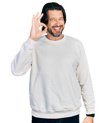 Middle age caucasian man wearing casual clothes smiling positive doing ok sign with hand and fingers. successful expression.