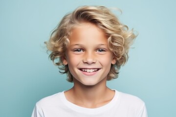 Portrait of a cute smiling little boy with blond hair over blue background - obrazy, fototapety, plakaty