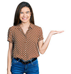 Young caucasian girl presenting with open palms, holding something smiling with a happy and cool...