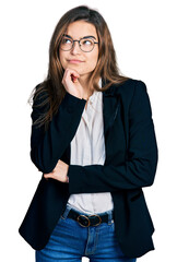 Young caucasian girl wearing business style and glasses with hand on chin thinking about question, pensive expression. smiling and thoughtful face. doubt concept.