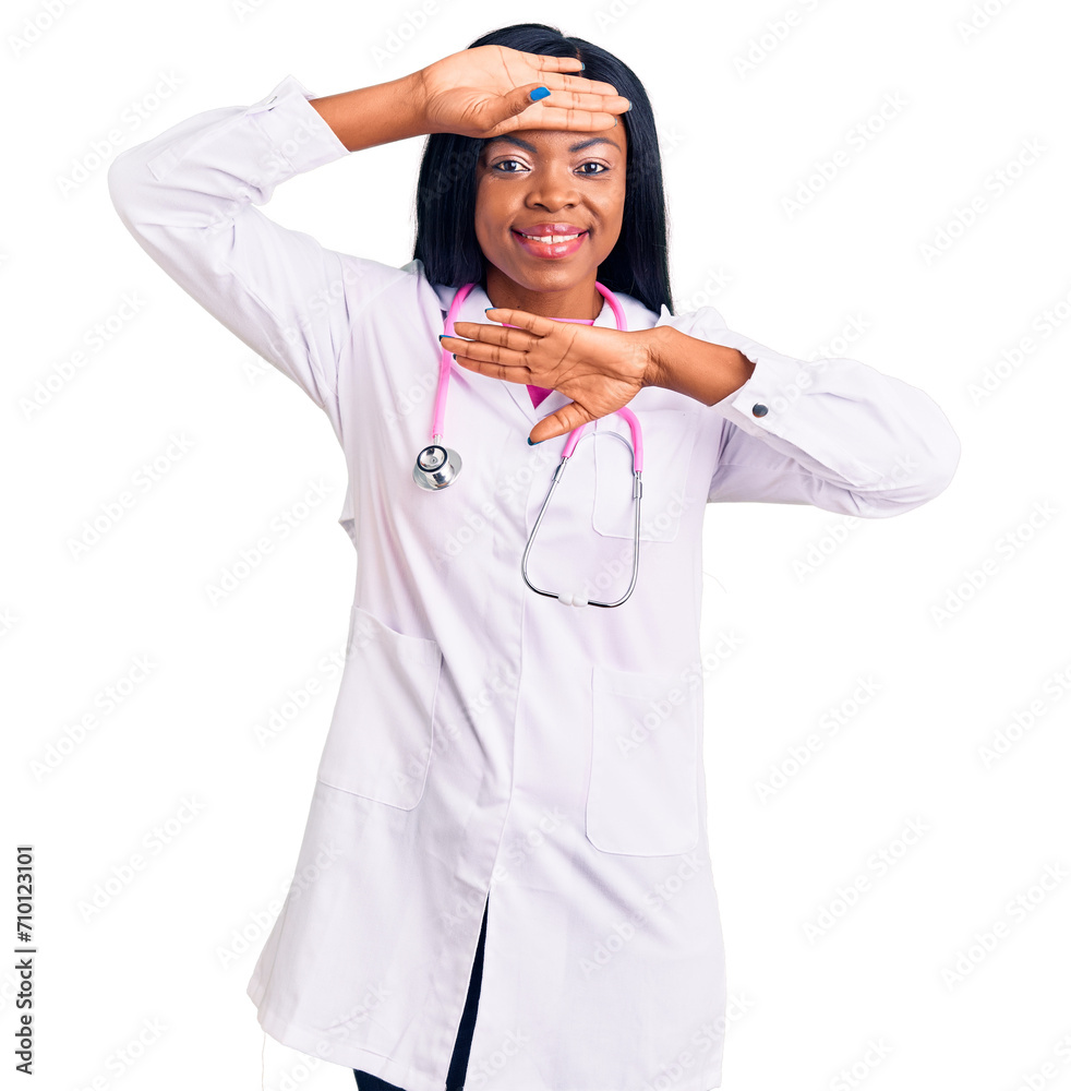 Sticker Young african american woman wearing doctor stethoscope smiling cheerful playing peek a boo with hands showing face. surprised and exited