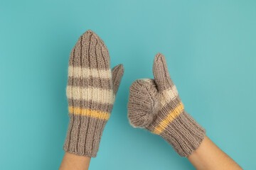 Hands in woolen knitted mittens.