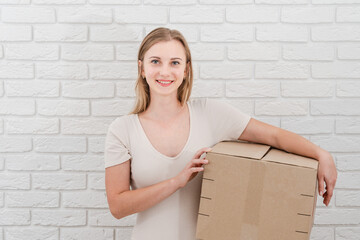 Pretty woman holding cardboard box. Delivering a parcel