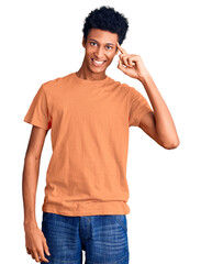 Young african american man wearing casual clothes smiling pointing to head with one finger, great idea or thought, good memory