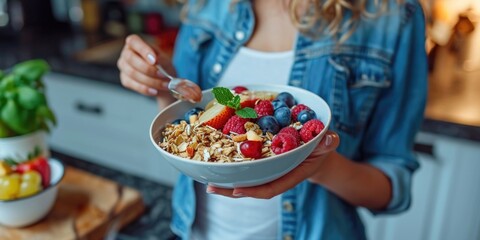 A woman holding a bowl of cereal and fruit. Ideal for breakfast or healthy eating concepts - obrazy, fototapety, plakaty
