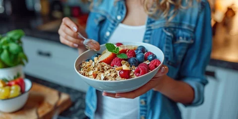 Poster A woman holding a bowl of cereal and fruit. Ideal for breakfast or healthy eating concepts © Fotograf