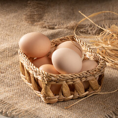 Homestead scene: chicken eggs on rural table covered with burlap cloth