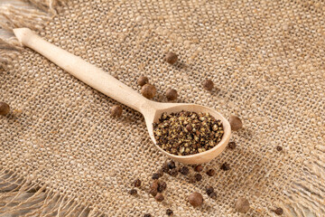 Peasant style setting with pepper grinder and finely ground black pepper on fabric napkin