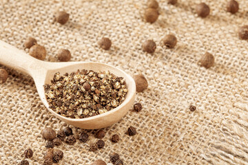 Rustic pepper grinder with freshly ground pepper on a traditional farmer's cloth napkin