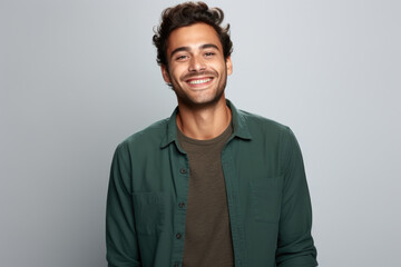Obraz premium Man wearing green shirt smiles while posing for picture. This image can be used for various purposes.