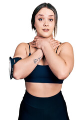 Fototapeta na wymiar Young hispanic woman wearing sportswear shouting and suffocate because painful strangle. health problem. asphyxiate and suicide concept.