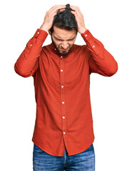 Young hispanic man wearing casual clothes suffering from headache desperate and stressed because pain and migraine. hands on head.