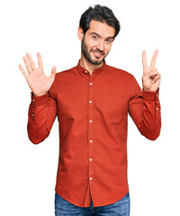 Fototapeta premium Young hispanic man wearing casual clothes showing and pointing up with fingers number seven while smiling confident and happy.