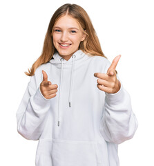Beautiful young caucasian girl wearing casual sweatshirt pointing fingers to camera with happy and...