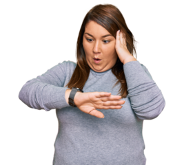 Beautiful brunette plus size woman wearing casual clothes looking at the watch time worried, afraid of getting late