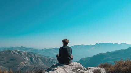 person sitting on a rock, observing a distant mountain range under a clear blue sky generative ai