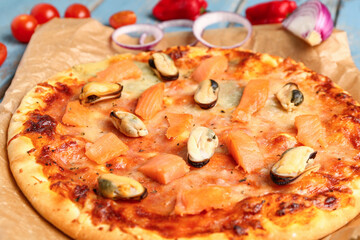 Tasty seafood pizza on blue wooden background, closeup