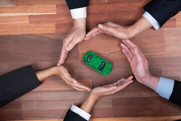 Top view business people holding EV car model as business synergy partnership unite and take action...