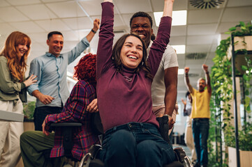 Woman who uses wheelchair celebrating winning in office chair race