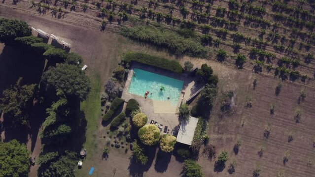 Drone footage of pool in the summer with surrounded by olive groves. Lauris, France
