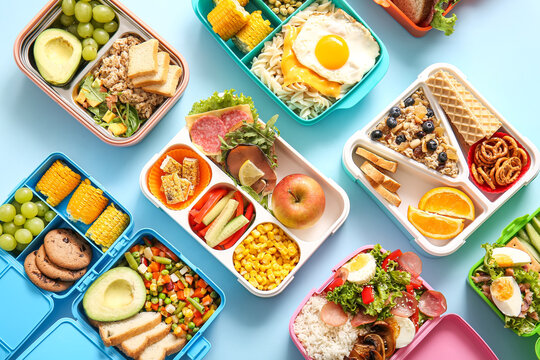 Many lunchboxes with different delicious food on blue background