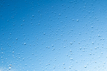 Raindrops on the glass against the blue sky.