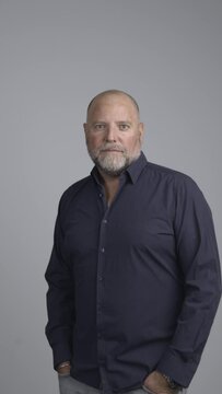 Portrait of well dressed man in studio with positive attitude looking into camera.