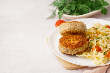 Plate of tasty meat cutlets with pasta on white background