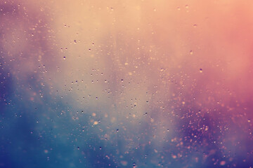 Raindrops on a window with a blurred pink and blue gradient background, conveying a calm, rainy day atmosphere.