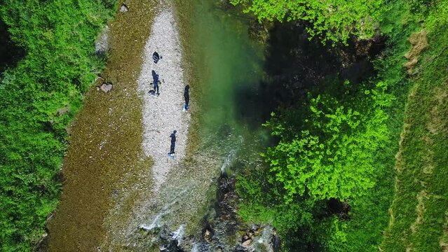 Drone footage of fisherman fly fishing in river in the mountains in summer. Mozirje, Slovenia