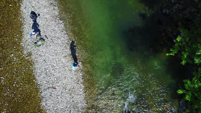 Drone footage of fisherman fly fishing in river in the mountains in summer. Mozirje, Slovenia