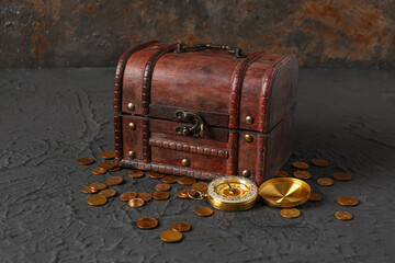 Old chest with treasure and compass on grunge brown background
