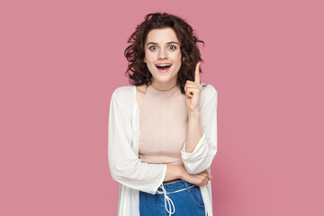 Portrait of clever smart happy woman with curly hair wearing casual style outfit raises her index...