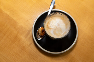 cup of coffee with a biscuit and spoon