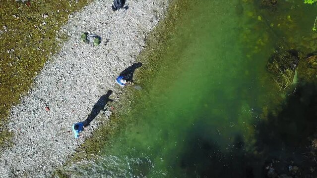 Drone footage of fisherman fly fishing in river in the mountains in summer. Mozirje, Slovenia