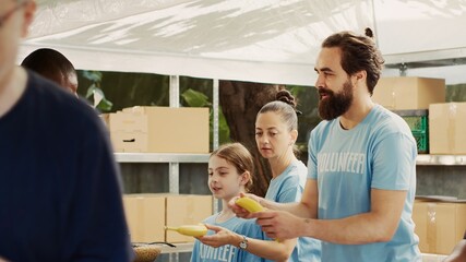 Male and female volunteers share food and provisions with less privileged during charity food...