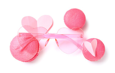 Pink sunglasses with macarons and paper hearts on white background. Valentine's Day concept