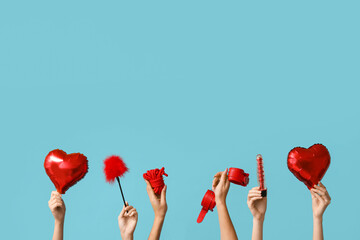 Many female hands with heart shaped balloons and sex toys on blue background. Valentine's Day...