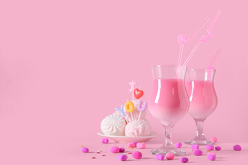 Glasses of tasty cocktail with candies and zephyr on pink background. Valentine's Day celebration