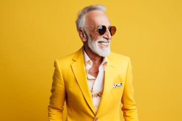 portrait of senior man in sunglasses and yellow jacket on yellow background - Powered by Adobe