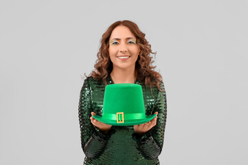 Woman with green hat on light background. St. Patrick's Day celebration