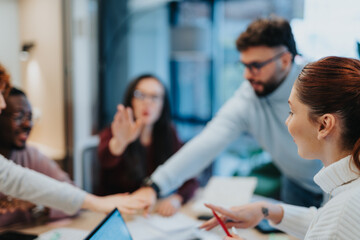 Work done. Multiracial business team celebrating success, victory or winning at the office. They are putting their hands together.