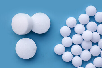 White mothballs on blue background.