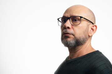 White man, bald, with prescription glasses, thoughtful and serious, looking to the side.