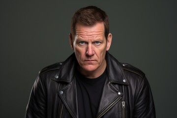 Portrait of a mature man wearing a leather jacket on a dark background