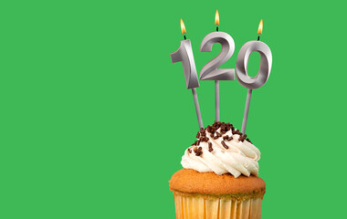 Birthday with number 120 candle and cupcake - Anniversary card on green color background