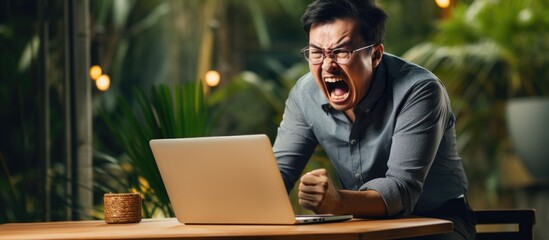Angry Asian employee frustrated by unreliable internet connection while working from home.