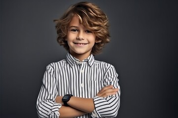 Portrait of a cute little boy with curly hair over grey background