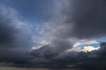 Fototapeta na wymiar Epic Dramatic storm dark grey and white cumulus rain clouds against blue sky background texture, thunderstorm